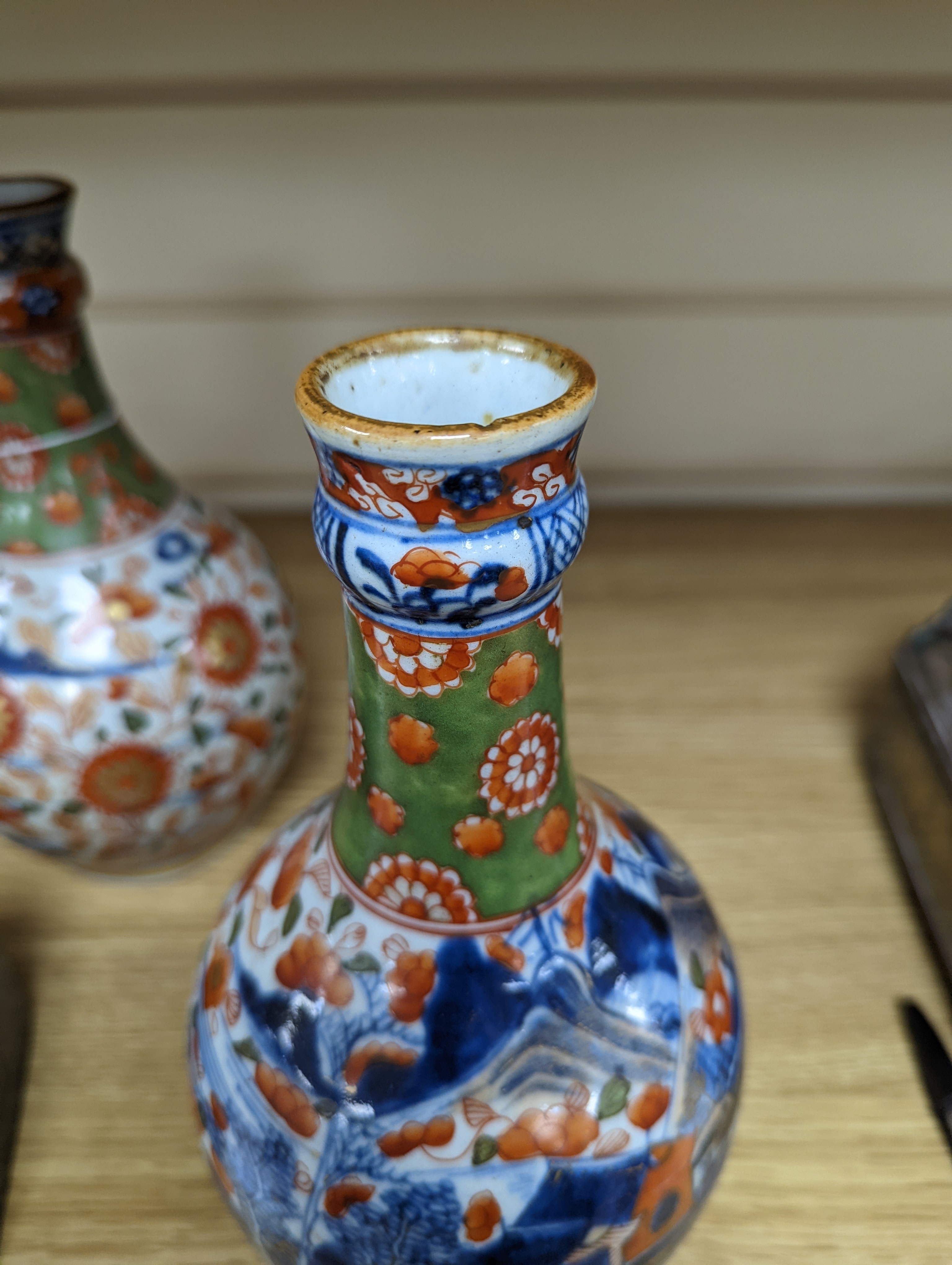 A pair of 18th century Chinese clobbered blue and white bottle vases 23cm